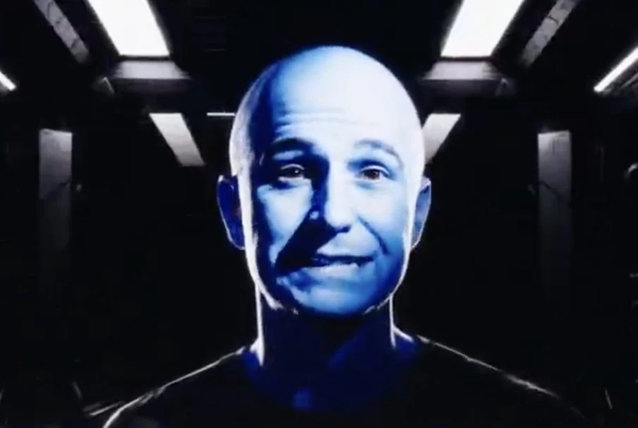 Commander Vrax, a bald villain lit in blue, on the starship viewscreen
